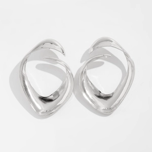 Detailed view of silver metallic bow earrings with irregular fluid wave and petal design