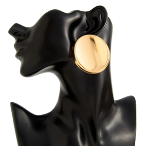 Polished gold circular stud earrings on model, featuring a large minimalist flat disc design