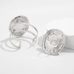 Dettaglio del set bracciale e anello in metallo liquido argento con trama martellata