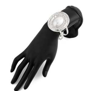 Dettaglio del bracciale rigido in metallo argento con grande perla ovale bianca lucida