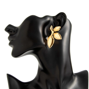 Macro detail of layered golden leaf earrings with polished finish on a model stand