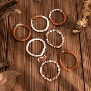Detailed view of brown and white heishi clay bead bracelets with a football charm