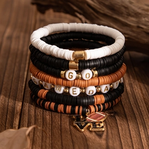 Macro detail of stacked heishi bead bracelets with GO GAMEDAY and football love charm