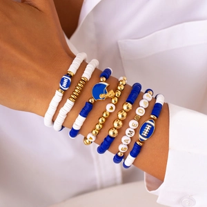 Detail of layered navy blue and gold beaded bracelets with football and helmet charms