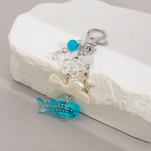Detailed shot of a blue whale shark pendant with decorative star and beads on key ring