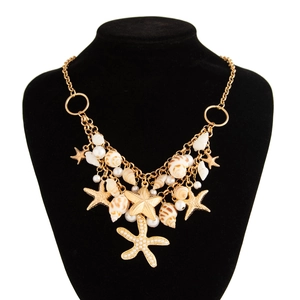 Detail view of gold layered waist chain featuring starfish, shells, and faux pearls