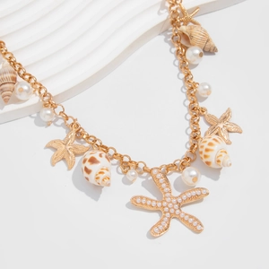 Detail of beach style necklace featuring golden starfish, natural shells and pearls