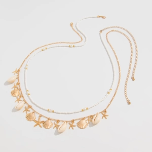 Detail of beaded waist chain with gold starfish pendants and natural shells for beach