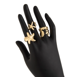 Macro detail of gold sea star and shell charms on a bohemian style body waist chain
