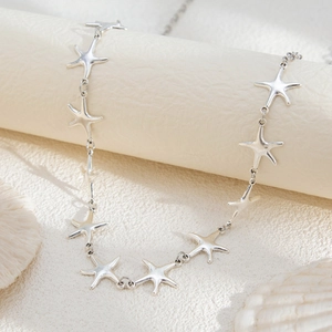 Close-up of silver starfish waist chain displayed on a professional jewelry stand