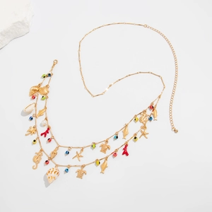 Detail of double-layer gold chain with seahorse, starfish, and shell charms and evil eye beads
