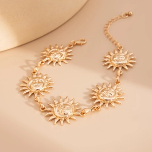 Detailed macro view of golden sun face pendants on a chic adjustable metal body chain