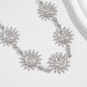 Close-up of celestial sun and moon face silver metal link body chain jewelry