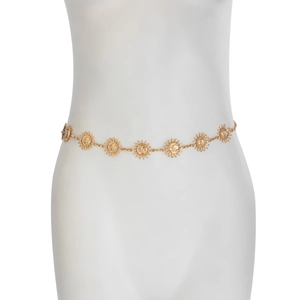Detail showing golden sun flower metal waist chain with embossed face pendants on model