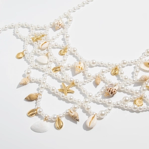 Detail view of multi-layer mesh body chain with pearls, shells and sea stars