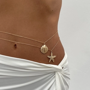 Detail of double-layer gold waist chain featuring starfish and seashell pendants