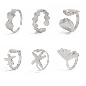 Detaillierte Nahaufnahme von sechs silberfarbenen Ringen mit Seestern- und Muschelmotiven