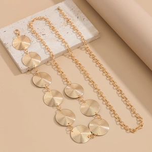 Detail of gold metal waist chain featuring textured circular disks and a lobster clasp