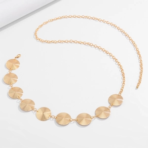 Detail of gold metal waist chain featuring nine spiral textured geometric discs and clasp
