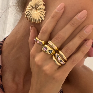 Modieuze gouden ringen set met kleurrijke edelstenen en een onregelmatige metalen oorbel