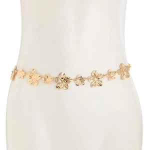Détail de la chaîne de taille dorée à fleurs sur mannequin montrant les maillons métalliques