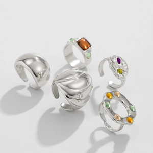 Vue macro détaillée de cinq bagues empilables en argent avec divers cristaux et textures