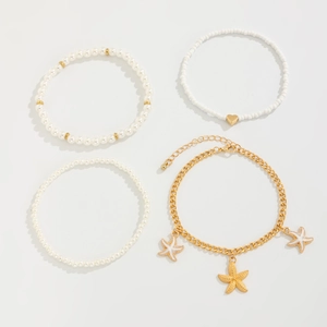 Détail d'un ensemble de quatre bracelets de cheville avec breloques étoile de mer