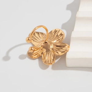 Detailaufnahme eines goldenen Ohrrings in Blumenform mit Textur auf 3D-Hintergrund