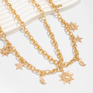Detail of gold metal body chain featuring celestial sun star and crescent moon charms