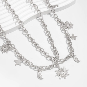 Close-up of silver metal waist chain with sun, moon and star charms on stone