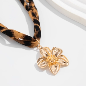 Detail of golden five-petal flower pendant with leopard print fabric necklace strap