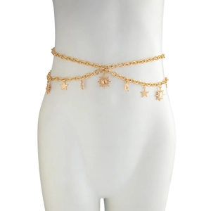 Detail of bohemian gold body chain featuring sun moon and star charms on white mannequin