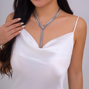 Detail of layered silver snake chain necklace with a knotted fringe design on model