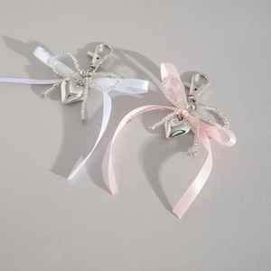 Porte-clés nœud ruban avec pendentif cœur argenté et détails perlés en rose et blanc