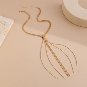 Close-up of golden tassel necklace with intricate knot detail and elegant snake chains