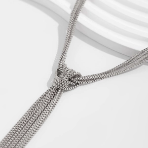 Detail of silver multi-strand box chain with knot craft and flowing tassel fringe