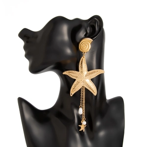 Detail von Gold Seestern und Schnecke Ohrringen mit langen Quasten und Kunstperlen