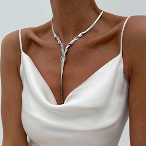 Detailed view of silver flat snake chain necklace with elegant knot and long tassel fringe