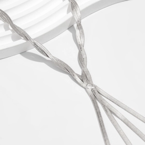 Detail of layered silver flat snake chain necklace with high-shine metallic texture
