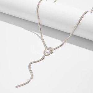 Detailed view of silver snake chain necklace with knot detail on white background