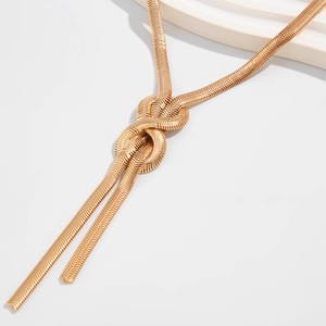 Chic gold flat snake bone chain necklace with elegant knot detail on white background