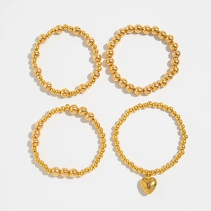 Detailed view of bohemian gold bead bracelet set with a charming heart pendant charm
