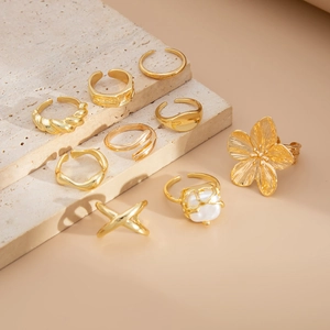 Detail van een 9-delige gouden ringenset met barokparels en lava bloemontwerpen