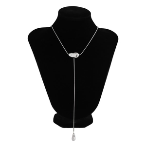 Detail view of silver Y-shaped necklace with bean element and teardrop pendant charm