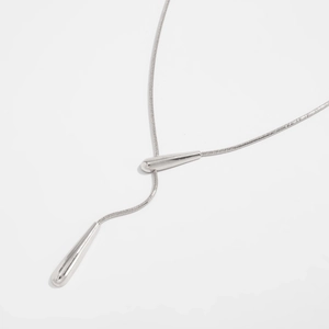 Detail of silver irregular hollow pendant on a fine snake bone chain Y-necklace