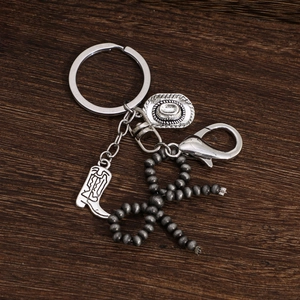 Détails des breloques vintage en argent avec chapeau et botte de cowboy sur un porte-clés
