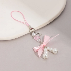 Detail of pink bow and star pendant mobile strap with pearls and woven lanyard