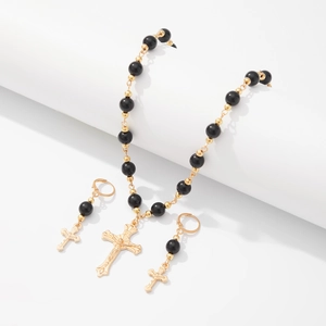 Détail du collier punk gothique à perles noires avec pendentifs en forme de croix dorée