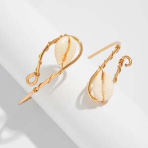 Close-up of gold wire-wrapped arm cuff with natural cowrie shell in bohemian style