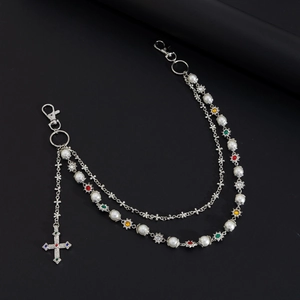 Close-up of layered silver chain with faux pearls, colored rhinestones and cross pendant